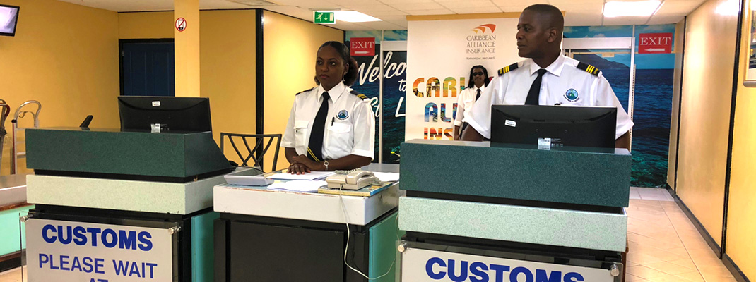 Customs officers at airport baggage counter.